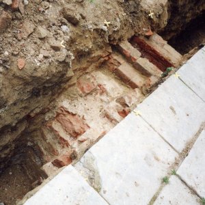 Obr. 48: Bučovice 2000. Sonda 18/2000. Ve výkopu pro kanalizaci byla zachycena mohutná zeď postavená z vysokých cihel nejspíše pozdně středověkého stáří. Tento relikt může být dokladem přítomnosti zbytklů gotické tvrze dosud ukrytých v prostoru nádvoří pod zemí – pohled od JV (foto P. Vitula).