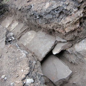 Obr. 55: Pernštejn – hrad 2007/1. Suchovod. Ve výkopech na 4. nádvoří vedených za pomoci lehké techniky byly odkryty ploché kameny střední a větší velkosti místy tvořící relikty někdejší kamenné dlažby. Prakticky v celé trase byla dlažba překryta novověkým hlinitokamenitým násypem se stavebním odpadem a ojediněle i druhotně přemístěnou pozdně středověkou keramikou – pohled od SZ (foto P. Vitula). – pohled od Z (foto P. Vitula).